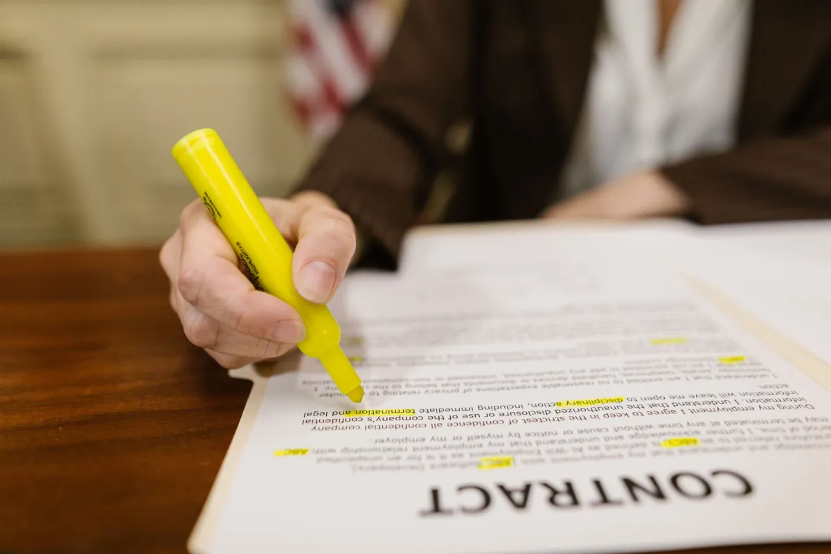 Person highlighting a legal contract at a desk representing the key privacy law terms and definitions needed to build an accurate data map