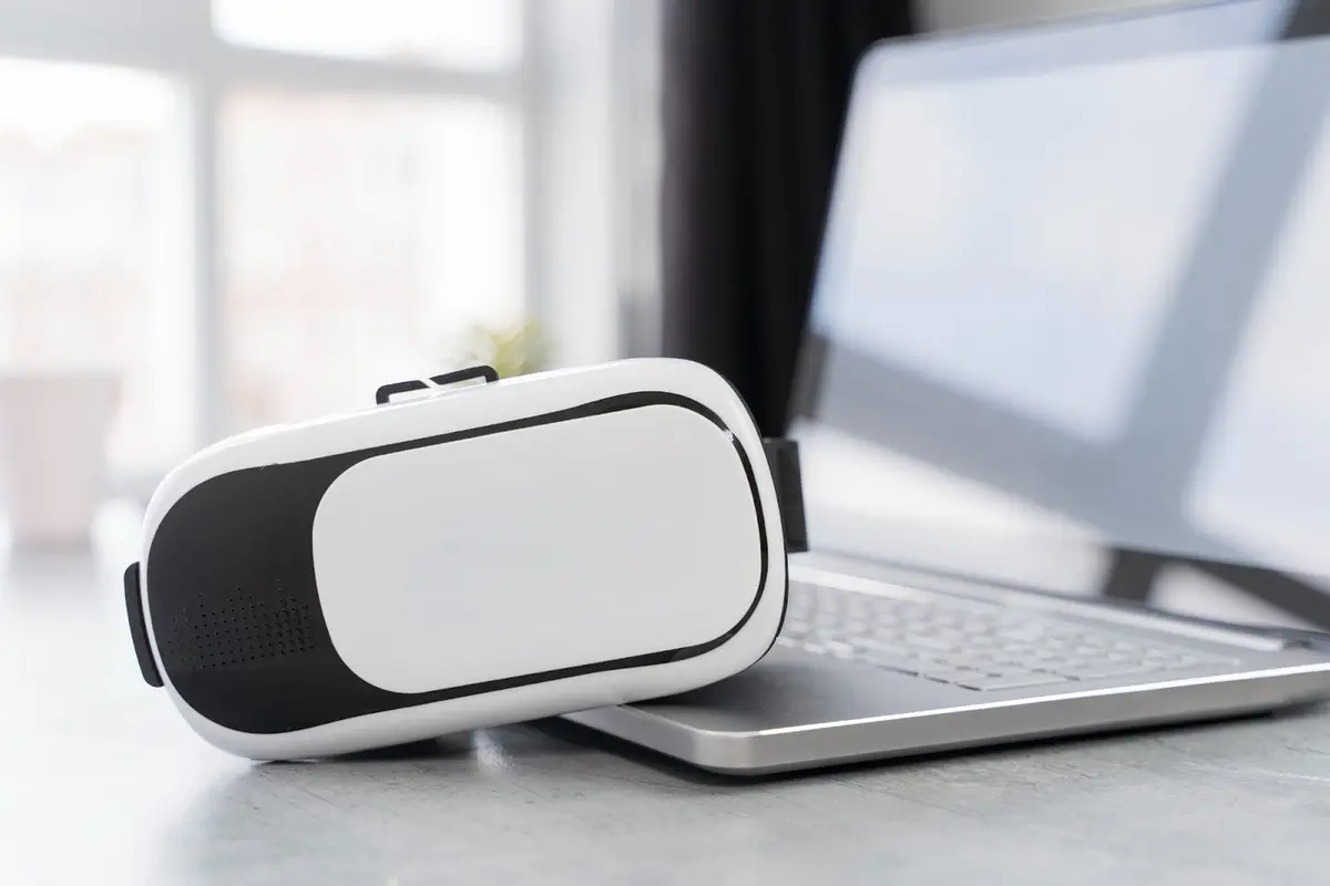 VR headset leaning against a laptop representing emerging technology trends under the Trump administration